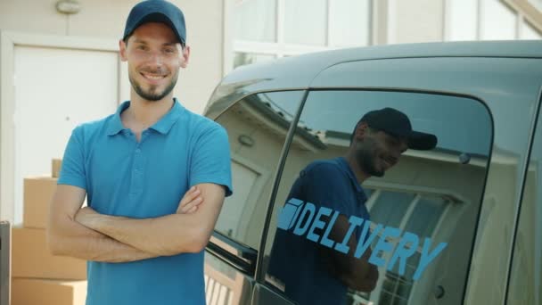 Retrato de câmera lenta de alegre entrega empregado sorrindo em pé perto de van comercial e parcelas — Vídeo de Stock