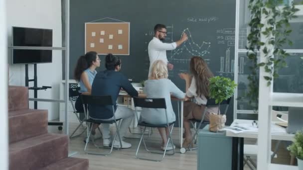 Zoom-in de equipe de negócios de sucesso discutindo o desenvolvimento de vendas e palmas no escritório — Vídeo de Stock