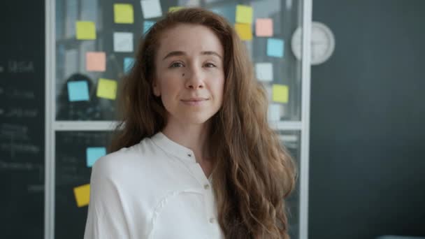 Portrait d'une jeune femme attrayante employée souriant à l'intérieur dans un bureau créatif — Video