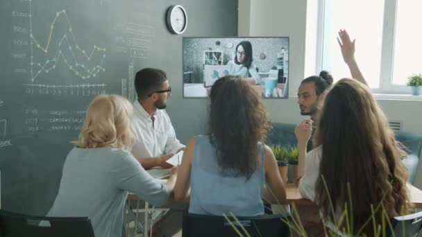 Des collègues hommes et femmes parlent à des femmes d'affaires par appel vidéo en regardant le moniteur dans le bureau — Video