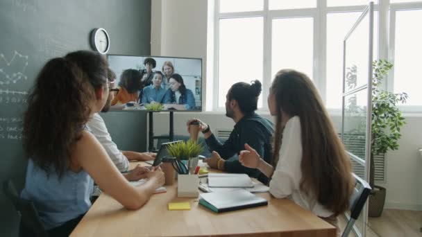 Grupa przedsiębiorców omawia pomysły z kolegami podczas rozmów wideo online w biurze — Wideo stockowe