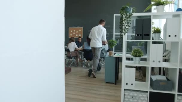 Trabalhador de escritório criativo montando scooter no local de trabalho fazendo high-five com colegas e palmas mãos celebrando boas notícias — Vídeo de Stock