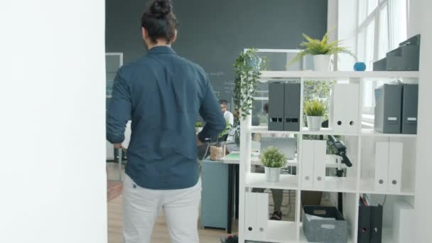 Oriente Medio hombre caminando en la oficina a continuación, ver a la joven mujer haciendo presentación con tablero interactivo — Vídeo de stock