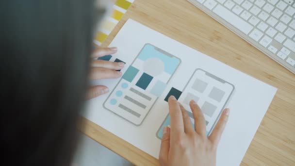 Közelkép a női tervezők kezét segítségével színpaletta és papír okostelefon alkalmazás képernyő — Stock videók