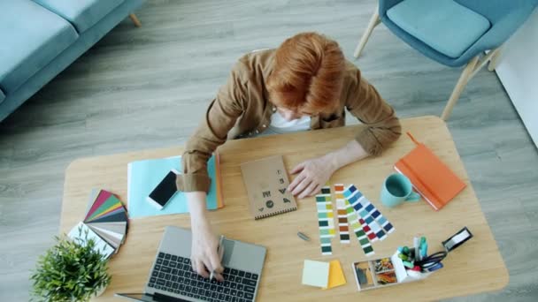 Vue grand angle des symboles de logo de dessin de jeune homme spécialiste et en utilisant un ordinateur portable à l'intérieur à la maison — Video