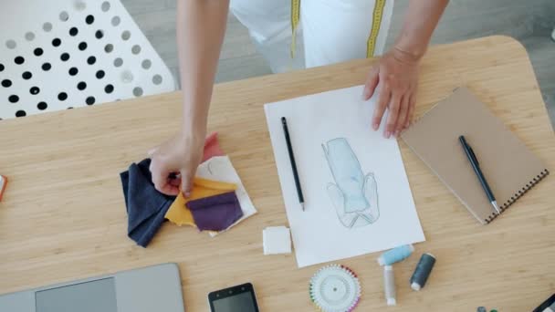 Közelkép a női ruha tervező választott szövet az új ruházat nézi vázlat kép — Stock videók