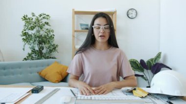 Neşeli bayan mimar video konuşması yapıyor. Evin içinde gülümseyen planlar gösteriyor.