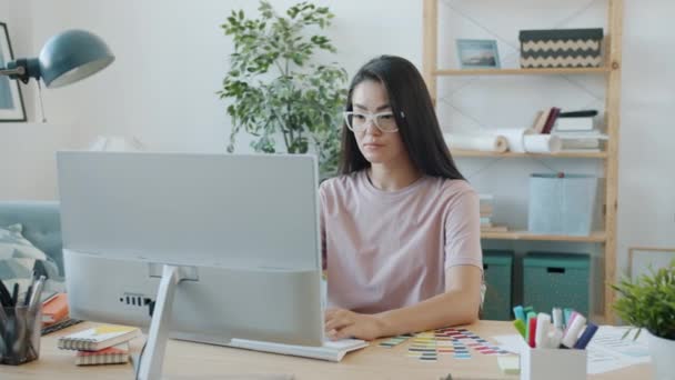 집에서 컴퓨터를 사용하여 일하는 젊은 아시아 갈색 머리 디자이너의 모습 — 비디오