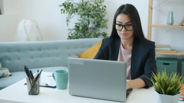 Κίνητρο ασιατική επιχειρηματίας γυναίκα που εργάζονται με φορητό υπολογιστή και πίνοντας τσάι στο σπίτι στο γραφείο — Αρχείο Βίντεο