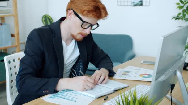 Портрет серйозного молодого бізнесмена, який працює в офісному написанні та використанні комп'ютера — стокове відео