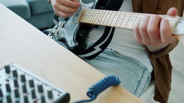 在公寓里弹奏电吉他录音歌曲的迷人男人的倒立肖像 — 图库视频影像