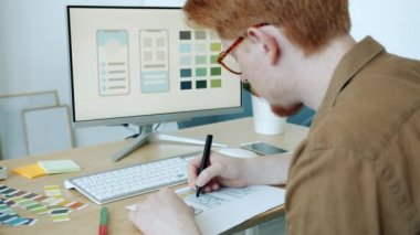 Bilgisayar monitörüne bakan cep telefonu uygulamaları için renk seçen yaratıcı uzman