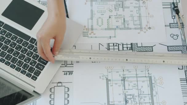 Wysoki kąt widzenia architektów ręce rysunek planu budowy i przy użyciu notebooka — Wideo stockowe