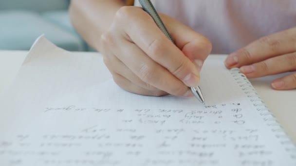 Primer plano de la escritura manual femenina en cuaderno tomando notas mientras el estudiante hace la tarea en el interior — Vídeos de Stock