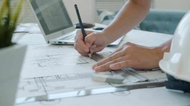 Close-up of female hands drawing on blueprint while architect is working at home — Stock Video