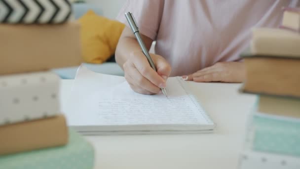 여학생 이 집에서 공부하는 동안 복사 책에 노트를 찍는 학생들의 근접느린 동작 — 비디오