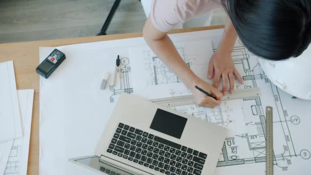 Vista de alto ângulo do plano de construção de elaboração de jovens especialistas trabalhando com papel e laptop no escritório — Vídeo de Stock