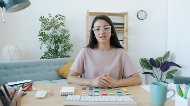 즐거운 여성 디자이너가 온라인 비디오를 보며 집에서 실내 전화를 하는 모습을 말하는 모습 — 비디오