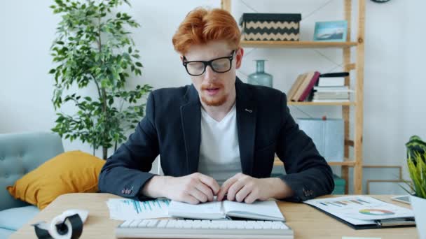 Ambicioso joven empresario haciendo presentación en línea desde casa hablando mostrando gráficos mirando a la cámara — Vídeo de stock