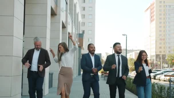 Разнообразная группа бизнесменов, танцующих на свежем воздухе в современном городе — стоковое видео