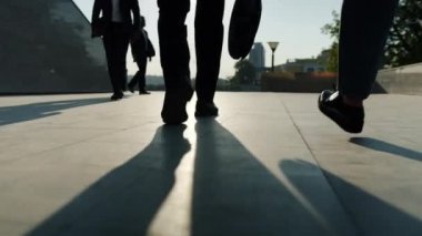 İş merkezinin yakınında resmi pantolonlar ve ayakkabılar içinde yürüyen bacakların alçak açılı görüntüsü