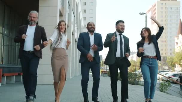 Multi-ethnic corporate team dancing and walking outdoors in business district — Stock Video