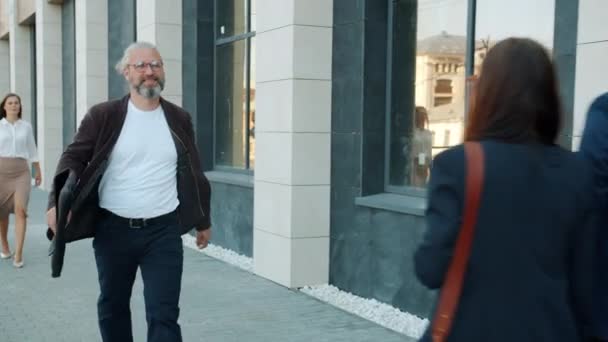 Movimiento lento de alegre empresario maduro caminando en la calle urbana riendo expresando felicidad — Vídeos de Stock