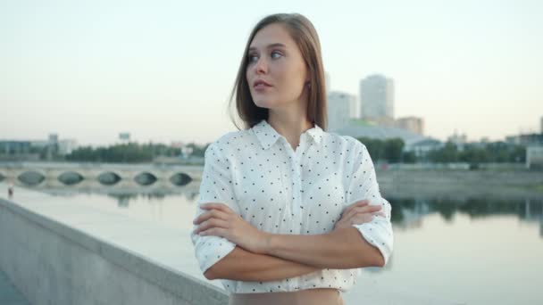 Potret ambisius wanita muda berdiri di tanggul di kota modern dan beralih ke kamera — Stok Video