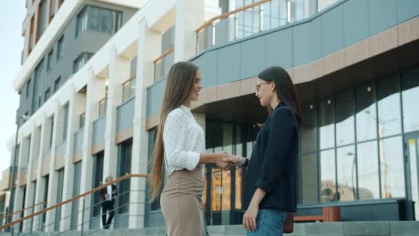 Sebevědomé mladé ženy, které se scházejí před kancelářským centrem, mluví a gestikulují — Stock video