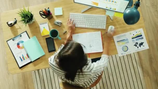 Временной интервал амбициозной деловой женщины за компьютером и записной книжкой, работающей за столом дома — стоковое видео