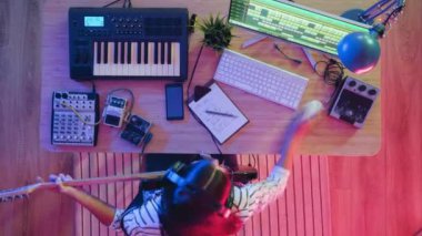 Aydınlatılmış odada enstrümantal müzik kaydeden kadın müzisyenin yakınlaştırma süresi