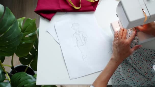 Крупним планом жіночі руки, що працюють з швейною машиною, створюють новий дизайнерський одяг — стокове відео