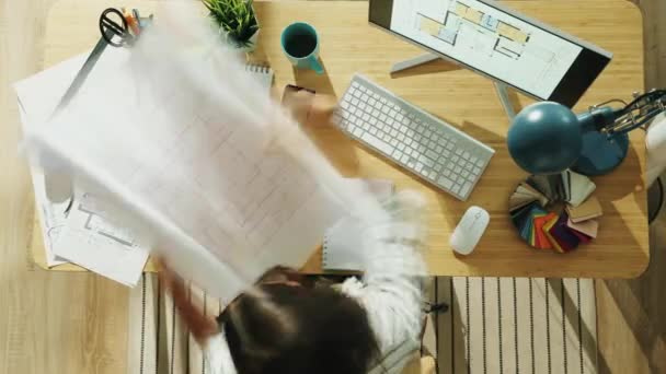 Top view time lapse of female architect busy with blueprints and computer writing working at desk — Stock Video