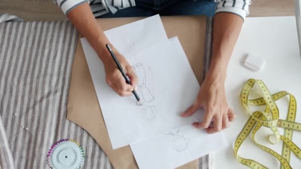 Kadınların el tasarımcıları atölyedeki masa başında kadın giysileri çiziyor. — Stok video
