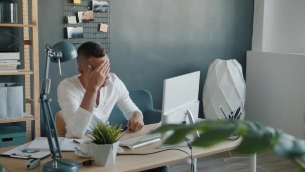 Trött och sömnig man som arbetar med dator på kontoret skriva rörande ansikte och ögon — Stockvideo