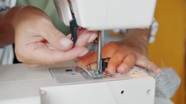Tasarımcıların yavaş çekimde yakın plan görüntüleri modern makinelerle kumaş dikiyorlar.