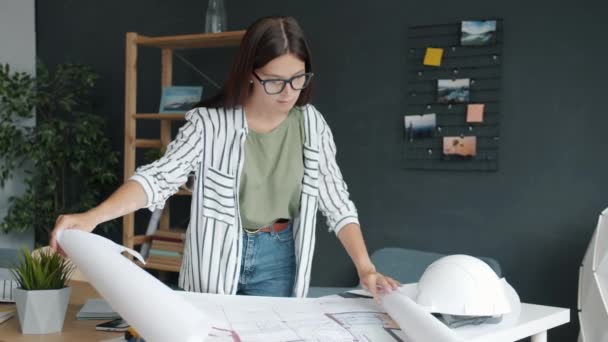 Portrait of freelance architect working with papers at home looking at blueprints and plans — Stock Video