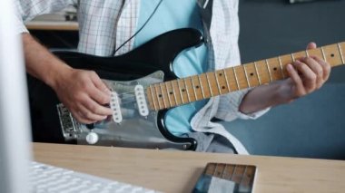 Gitaristlerin yavaş çekimde yakın çekimde stüdyoda elektrikli çalgılar çalması.