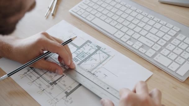 Close-up de planta de construção e mãos masculinas medindo e fazendo anotações em papel — Vídeo de Stock