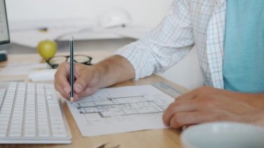 Mimarlar işleriyle meşgulken erkek işçilerin inşaat planıyla yakın plan çekimleri.