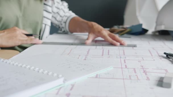 Zbliżenie kobiecych rąk architektów mierzących plan za pomocą narzędzi i zapisujących informacje — Wideo stockowe