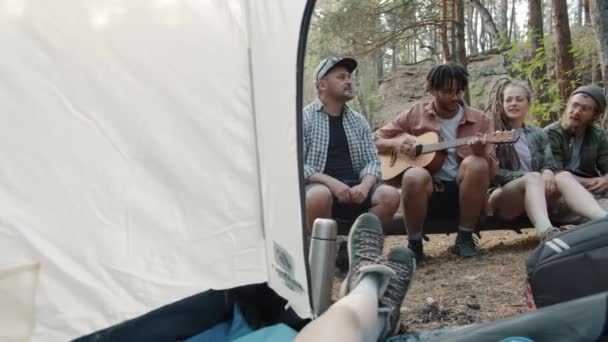 Mutlu kampçıların portresi. Ormanda tatilde müzik dinliyorlar. Çadırda gitar çalıyorlar. — Stok video