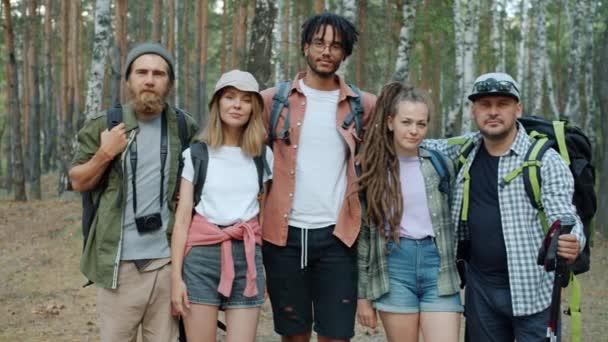 Zeitlupe Porträt von glücklichen Menschen vielfältige Gruppe steht im Wald mit Rucksäcken lächelnd — Stockvideo