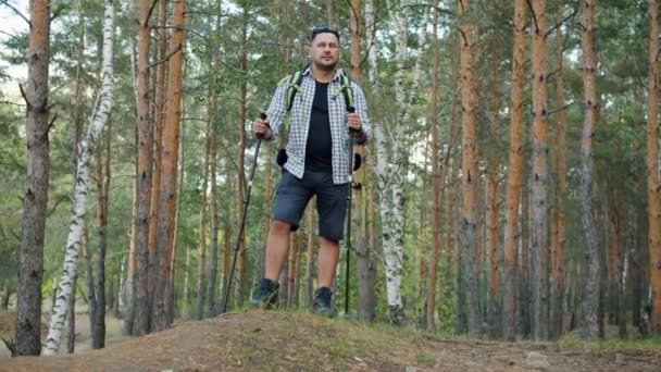 Zeitlupe des Wanderers, der an einem Sommertag im Wald steht und dann mit Stöcken läuft — Stockvideo