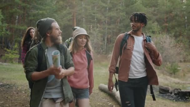 Grupa młodych ludzi podróżujących pieszo po lesie gospodarstwa map rozmowy i gestykulacji — Wideo stockowe
