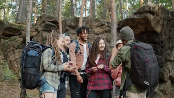 Grupo de amigos turistas charlando y uniendo sus manos expresando unidad y unidad de pie en el bosque — Vídeos de Stock