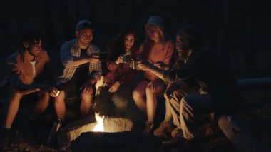Kaygısız turistler bardakları tokuşturuyor sonra da içiyor geceleri ateşin etrafında oturuyorlar.