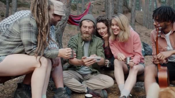 Ευτυχισμένοι νέοι τουρίστες που χρησιμοποιούν smartphone συγκινητική οθόνη και γέλιο έξω στο δάσος του φθινοπώρου — Αρχείο Βίντεο