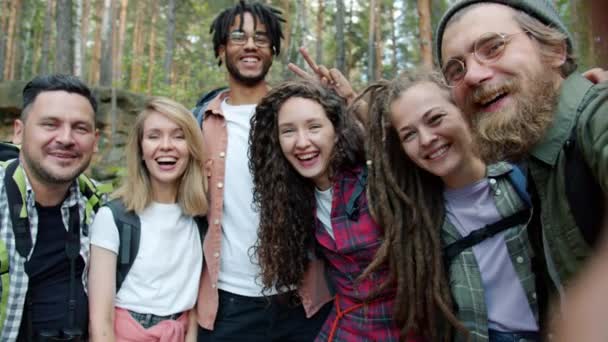 숲 속에서 카메라를 보면서 웃으면서 셀카를 찍고 있는 행복 한 청소년 친구들의 느린 동작 POV 사진 — 비디오