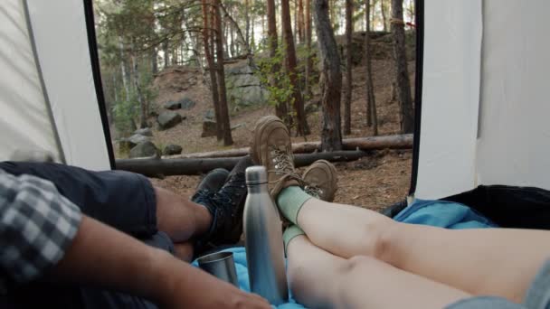 Gros plan des jambes touristes couchés dans la tente pieds mobiles relaxant bénéficiant d'une belle vue sur la forêt à l'extérieur — Video